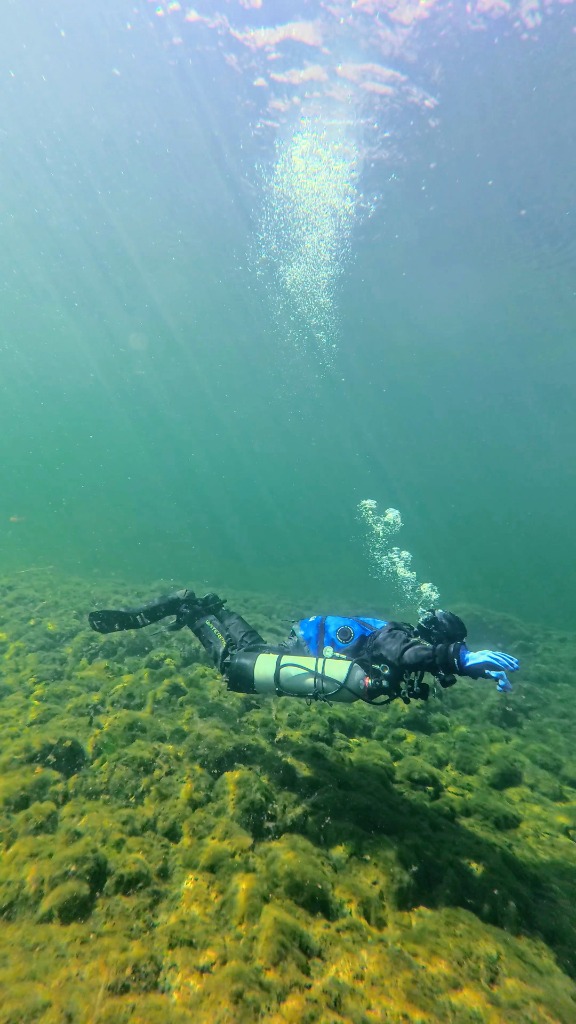 A diver in excellent horizontal trim using a sidemount cylinder configuration